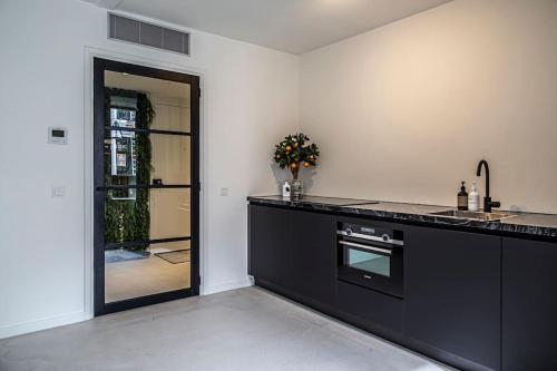 una cocina con encimera negra y puerta en Cloud Nine - romantic & design app in city center! en Dordrecht