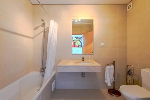 a bathroom with a sink and a tub and a toilet at Apartamento Bonita - Fuseta in Fuzeta