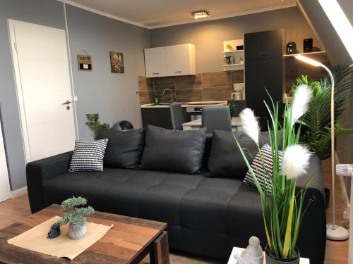 a living room with a black couch and a table at Stadtnah an der Förde 7 DG ML in Flensburg