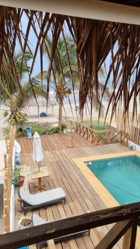 a resort with a swimming pool and a wooden deck at Hermosa casa de playa frente al mar in Los Órganos