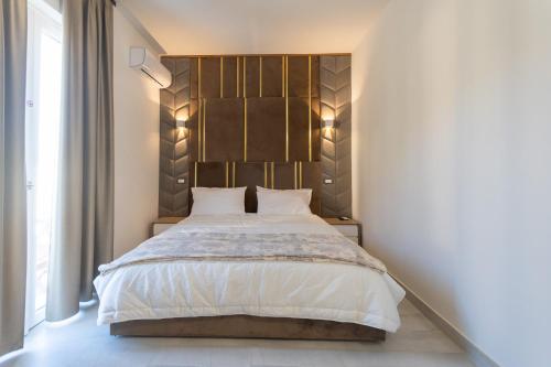 a bedroom with a large bed with a wooden headboard at 23Apartments in La Spezia