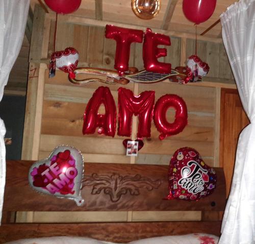 Una habitación con una señal que dice amor y globos en la casita del arbol guaduas cundi. en Guaduas