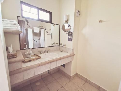 a bathroom with a sink and a mirror at Hotel Hacienda Los Laureles in Oaxaca City