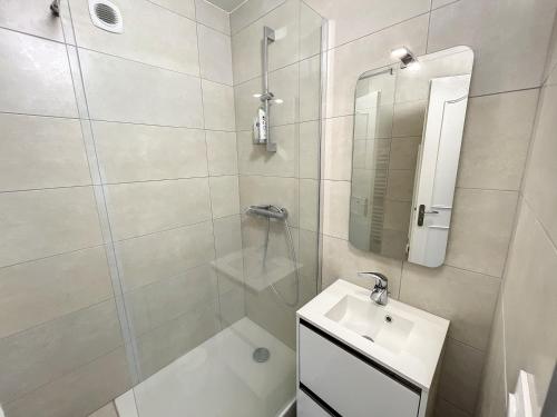 ein weißes Bad mit einem Waschbecken und einer Dusche in der Unterkunft Appartement Donville-les-Bains, 3 pièces, 4 personnes - FR-1-361-433 in Donville-les-Bains