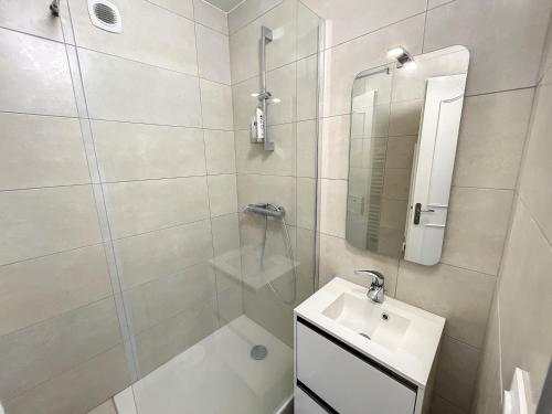 a white bathroom with a sink and a shower at Appartement spacieux près de la plage et commerces, 4 couchages - FR-1-361-433 in Donville-les-Bains