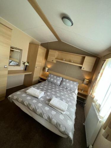 1 dormitorio con 1 cama con 2 almohadas en Lotus Lodge Northumberland, en Felton
