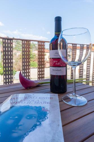 a bottle of wine and a wine glass on a table at 23Apartments in La Spezia