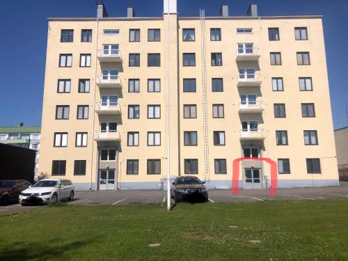 a large building with cars parked in a parking lot at Studio in the center with free private parking in Kemi