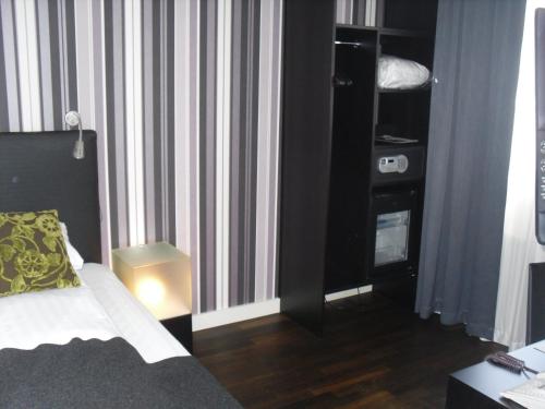 a hotel room with a bed and a book shelf at First Hotel Witt in Kalmar