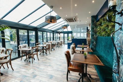 a restaurant with tables and chairs and windows at The Little Inn at Grasmere in Grasmere