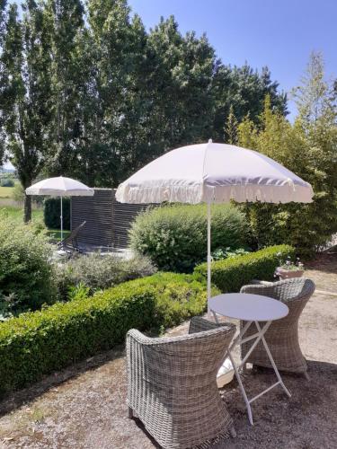 a table and two chairs and an umbrella at B&B In 't Stille Weg in Kemmel