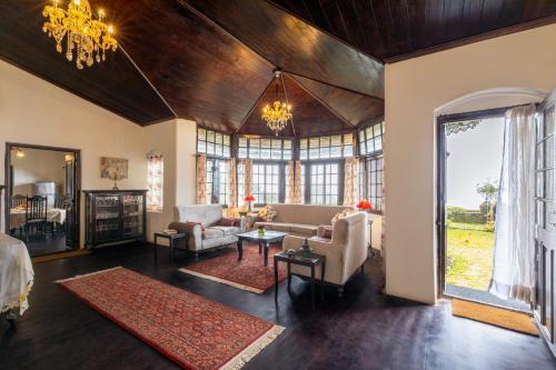 a living room filled with furniture and a chandelier at amã Stays & Trails - Wayside Villa, Kurseong in Karsiyang