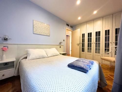1 dormitorio con 1 cama blanca y 1 silla en Dos Torres Conde Aranda - Céntrico con estacionamiento Incluido en Zaragoza
