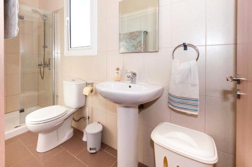 a white bathroom with a sink and a toilet at Molly's Villa in Protaras