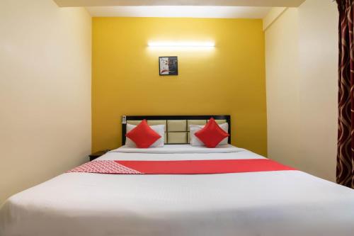 een slaapkamer met een bed met rode kussens bij OYO Hotel Royal INN Near Nexus Mall Koramangala in Bangalore