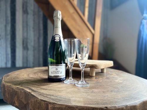 une bouteille de vin et deux verres sur une table dans l'établissement gite le petit marin, au Crotoy