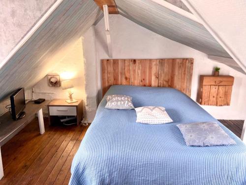 - une chambre mansardée avec un lit bleu dans l'établissement gite le petit marin, au Crotoy