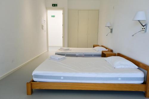 two twin beds in a room with two lamps at Albergue de Santa Luzia in Viana do Castelo