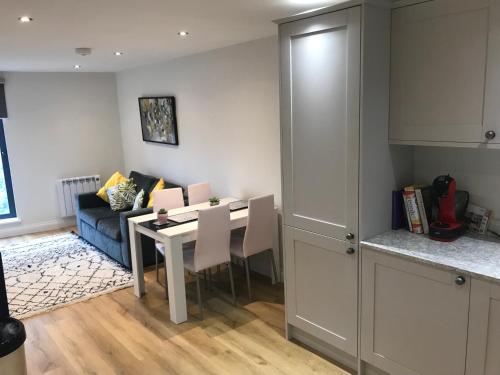 a kitchen and living room with a table and a couch at Heart of Henley 1 & 2 Bedroom Apartments in Henley on Thames