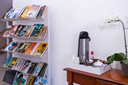 a room with a desk with books on a wall at Pousada Castelinho in São Sebastião