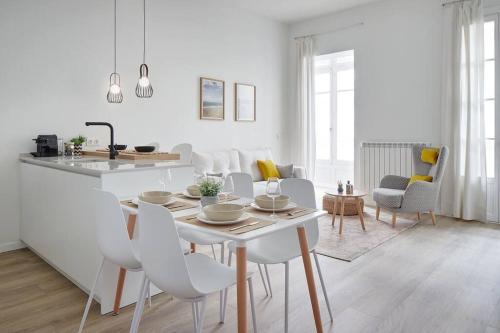 cocina y sala de estar con mesa y sillas en NUEVO Apartamento en el centro de Donosti, en San Sebastián