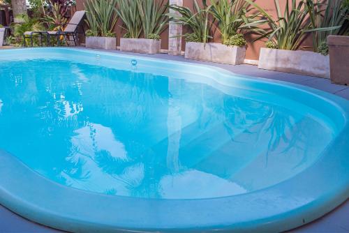 a blue swimming pool with plants in the background at Pousada Castelinho in São Sebastião