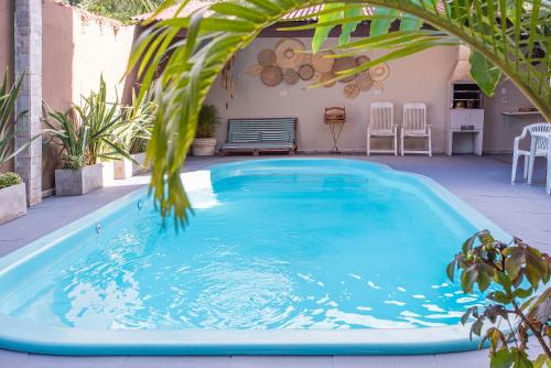 a swimming pool in a backyard with a palm tree at Pousada Castelinho in São Sebastião