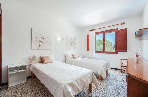 a white room with two beds and a window at Tacaritx de Bonaire, with pool and garden in Alcudia