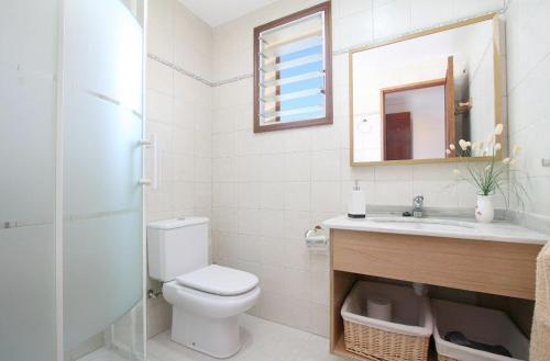 a bathroom with a toilet and a sink and a mirror at Tacaritx de Bonaire, with pool and garden in Alcudia