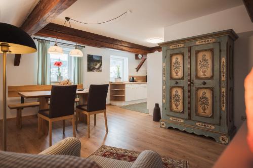 a living room with a table and a large cabinet at Altes Pfarrhaus in Altaussee