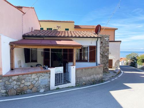 una casa in una strada con l'oceano sullo sfondo di Casa Giovanni - Pomonte a Pomonte