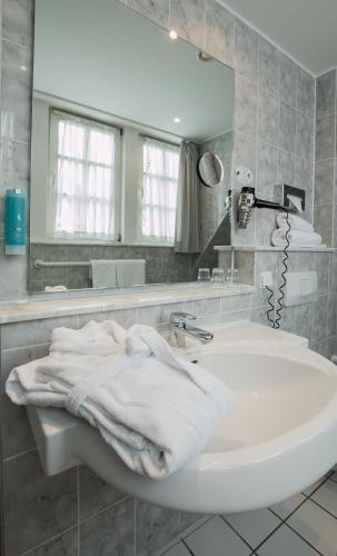 a white bathroom with a sink and a mirror at Historik Hotel Garni Christinenhof in Hameln