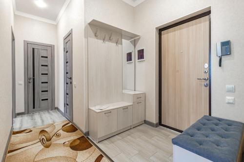 une salle de bain avec une grande porte et une chaise bleue dans l'établissement Жк Millennium Park,на Главной площади страны., à Astana