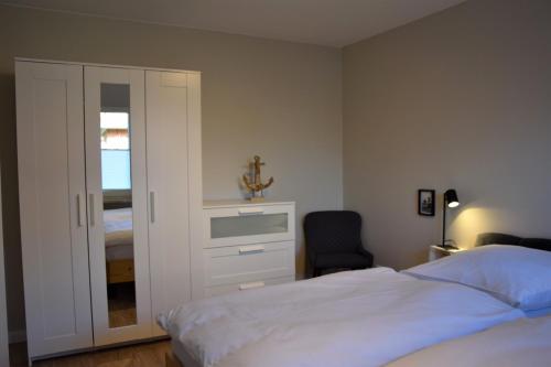 a bedroom with a bed and a cabinet with a cross on it at Ferienwohnung Dünenbutze in Büsum