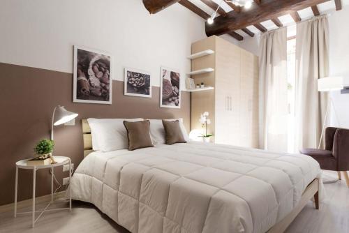 a bedroom with a large white bed and a chair at Flat with whirlpool bath in the historic centre in Perugia