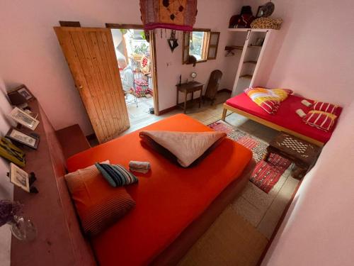 an orange couch in a room with a bedroom at SALAS waveclimbing company in Sidi Ifni