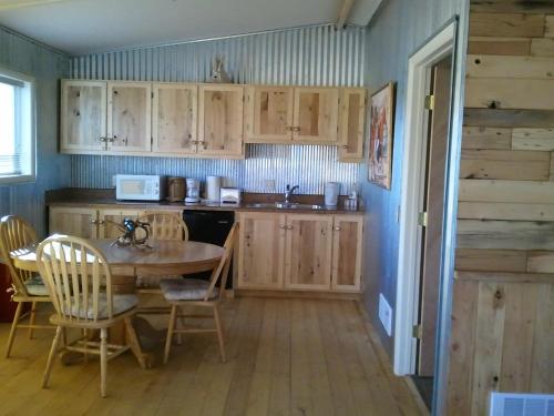 a kitchen with wooden cabinets and a table and chairs at K3 Guest Ranch in Cody