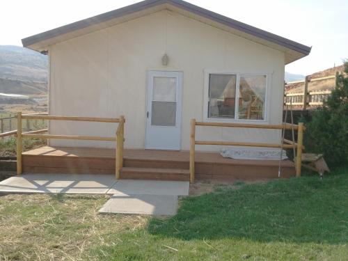 a small white house with a porch and a door at K3 Guest Ranch in Cody