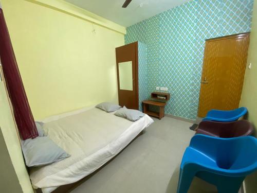 a bedroom with a bed and a blue tiled wall at Family Guest House Pondicherry in Vānūr