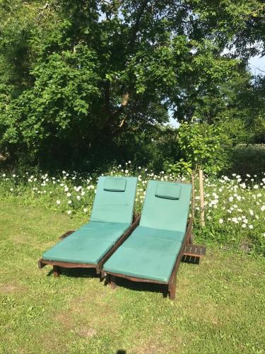 two lounge chairs sitting on the grass in a field at Glatigny Farmhouse - close to beach - proche de la plage in Glatigny
