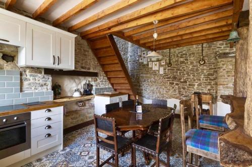 a kitchen with a table and chairs and a brick wall at Glatigny Farmhouse - close to beach - proche de la plage in Glatigny
