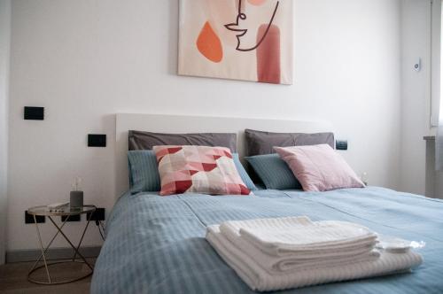 een slaapkamer met een blauw bed met handdoeken erop bij Casa Nicho Salo' in Salò