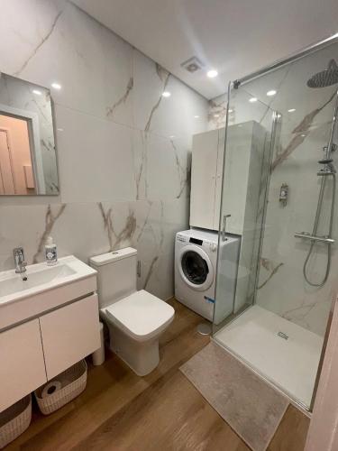 a bathroom with a shower and a toilet and a sink at RETIRO 402 in Guimarães