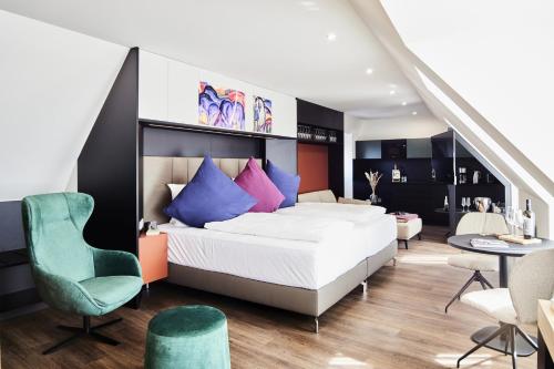 ein Schlafzimmer mit einem großen weißen Bett mit bunten Kissen in der Unterkunft Design- und Kunsthotel München in München