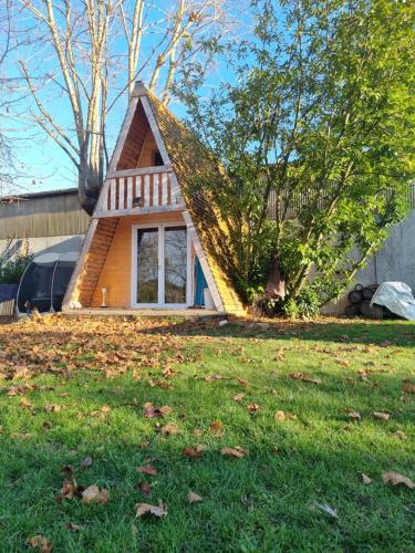 una pequeña casa con un techo inclinado en un patio en Le Chalet Tipi avec jacuzzi et jardin en Troyes