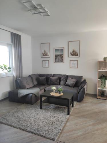ein Wohnzimmer mit einem Sofa und einem Couchtisch in der Unterkunft Ferienhaus Luna am schönen Harkebrügger See mit Kamin in Barßel