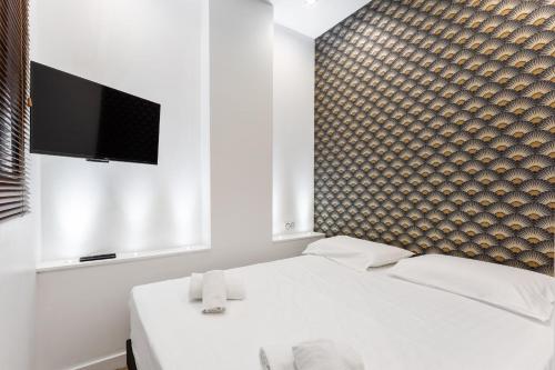 une chambre avec un lit blanc et une télévision à écran plat dans l'établissement Appartement Marble - Welkeys, à Nice