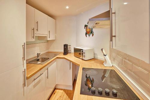 una pequeña cocina con fregadero y microondas en Finest Retreats - Mowbray, en Harrogate