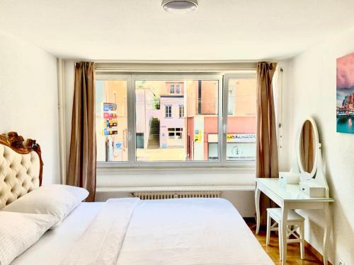 sypialnia z łóżkiem, biurkiem i oknem w obiekcie City Apartment - close to town - by PA w Lucernie