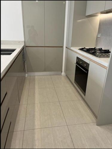 a kitchen with white cabinets and a stove at Comfort Living - 3 Bedroom sleeps 6 , parking, pool, other amenities - Near Showgrounds, NO PARTIES in Sydney